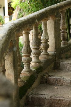 Close up view of the carving on an old weathered ornate stone balustrade in a garden
