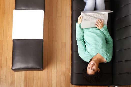 A young, brazilian woman surfing on the Internet with a Laptop.  