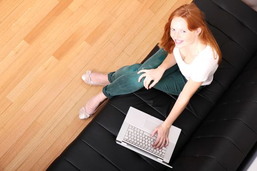 A young, brazilian woman surfing on the Internet with a Laptop.  