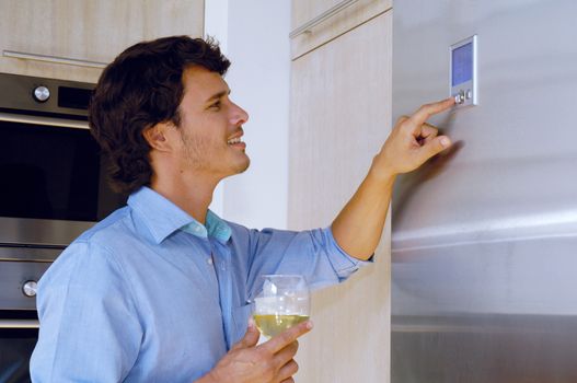 Young man looking on refrigerator 