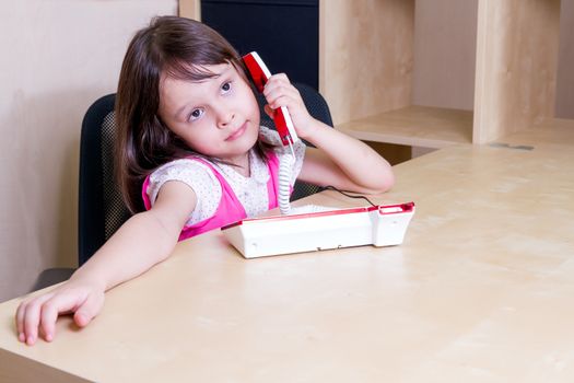 Asian child in office talking on telephone