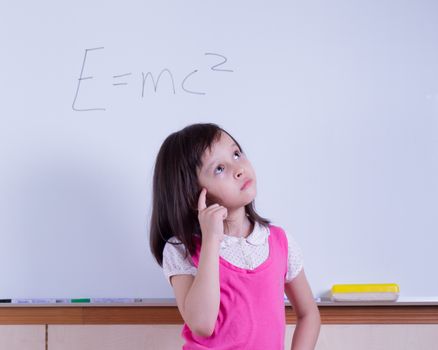 Child at whiteboard thinking about E=MC2