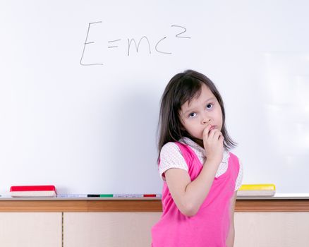 Child at whiteboard thinking about E=MC2