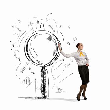 Image of young businesswoman leaning on magnifier