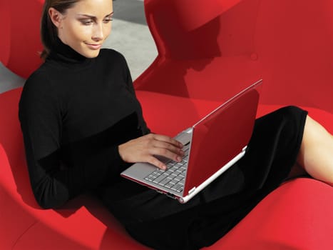 Beautiful young smiling woman with laptop on the sofa - indoors