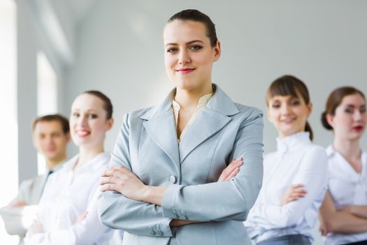 Young smiling businesswoman with colleagues. Leadership concept