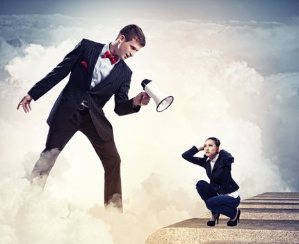 Angry businessman with megaphone shouting at colleague