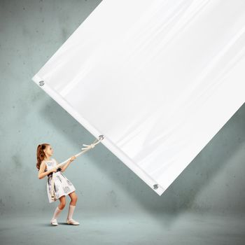 Little pretty girl pulling blank banner. Place for text