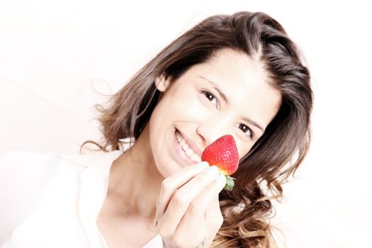 Portrait of a beautiful, latin Woman eating a Strawberry.