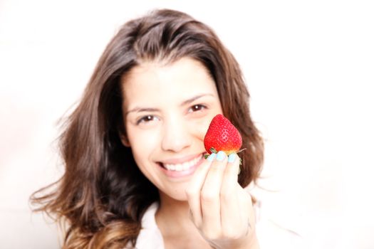 Portrait of a beautiful, latin Woman eating a Strawberry.