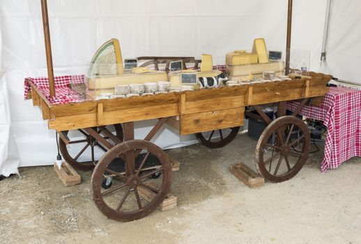 wooden car with cheese for sale on the market