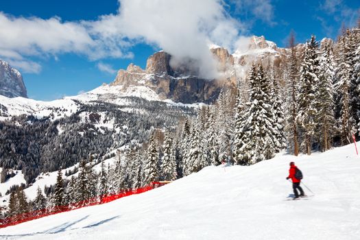 Skier going down the slope at Sella Ronda ski route in Italy