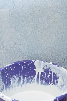 Background - House Improvement: Bucket Full of White Paint in Front of Wall