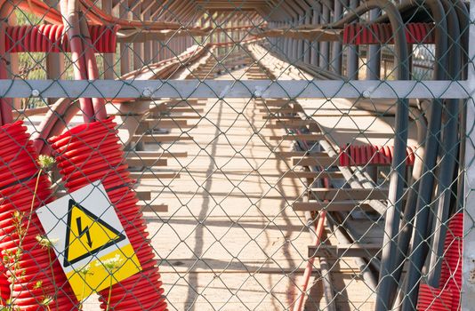 High Voltage Sign and Electric Distribution System Behind The Fence
