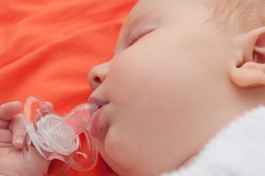 Close-up of Face of Sleeping Newborn Baby - Shallow Depth of Field - Focus on Mouth and Pacifier