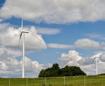 three-bladed wind generator with a horizontal axis of rotation on sky background