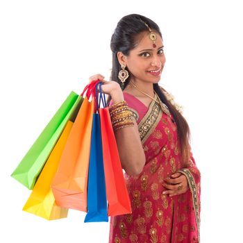 Portrait of beautiful young Indian woman in traditional sari dress shopping, standing isolated on white background.