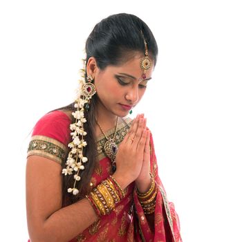 Portrait of beautiful young Indian woman prayer in traditional sari dress, isolated on white background.