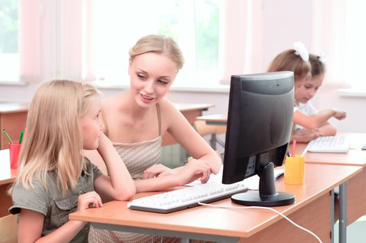 teacher explains the task schoolgirl at the computer, the new technologies in education