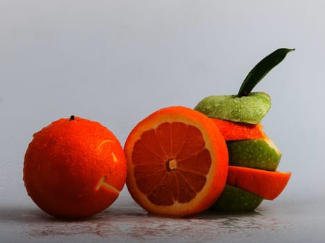 The combination of a smiling orange, and beat up pieces of apples and oranges