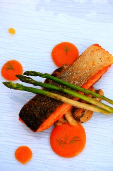 Grilled salmon steak with asparagus in glass dish