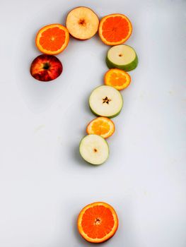 Photo cut oranges and apples arranged in a question mark