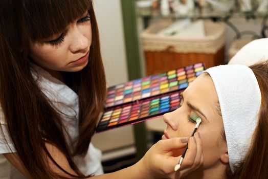 Young woman getting beautiful makeup in a beauty salon