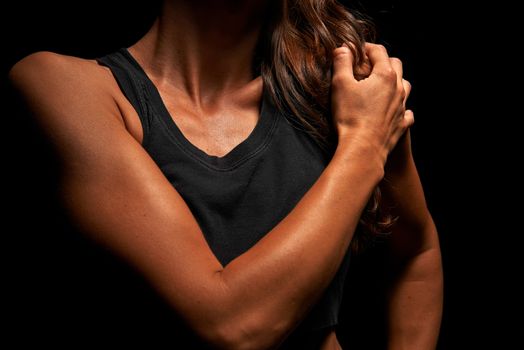 Upper body of a muscular woman in a studio