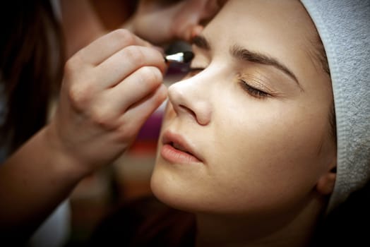 Young woman getting beautiful makeup in a beauty salon