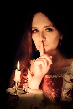 Girl holding a candle in a vintage dress.