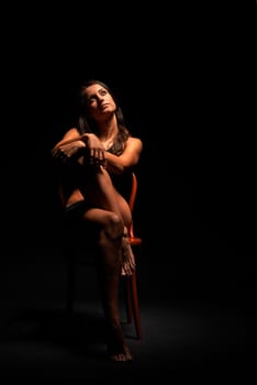 Young muscular woman under bright light in a studio