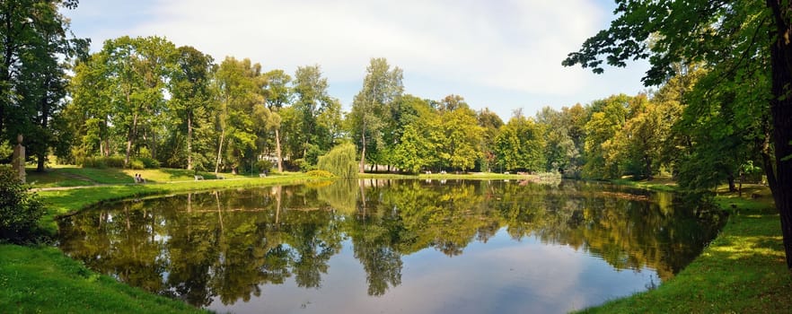 Lake and park in Wilanow Royal Garden in Warsaw. Wide angle panoramic view.