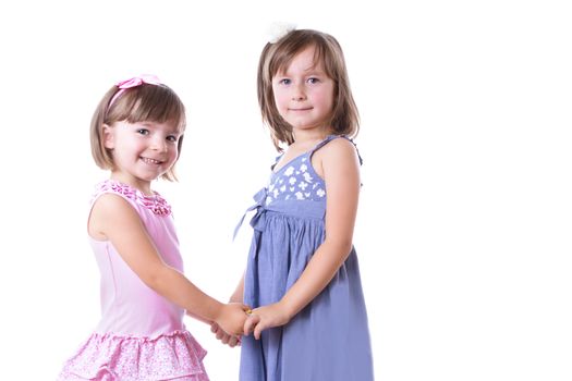 Two happy girls sisters holding by hands isolated on white