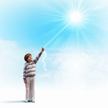 Image of little cute boy catching sun with rope