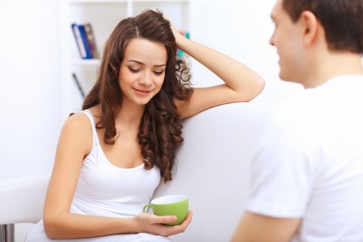 Young happy couple at hone together sitting and talking