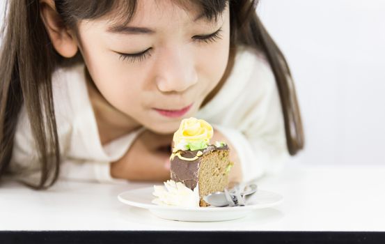 The girl stared cake for overcome by a temptation to eat a slice of a sweet cake