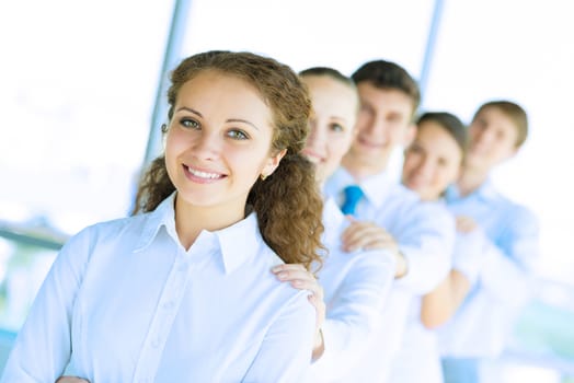 portrait of a young business woman standing in line with colleagues, concept of teamwork