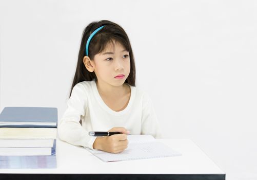Young girl working in classroom on white background