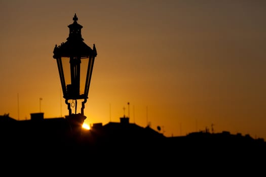 Ancient lamp in Prague against sunrise