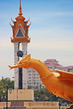 Statue and the clock tower in Wat Bottom park in Phnom Penh, Cambodia