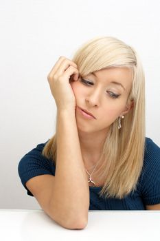 A studio close-up of a lovely young bored blonde.