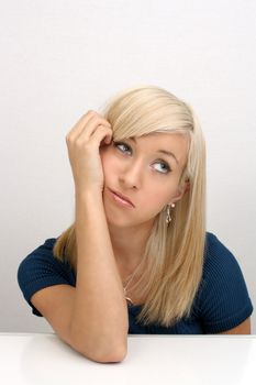 A studio close-up of a lovely young bored blonde.