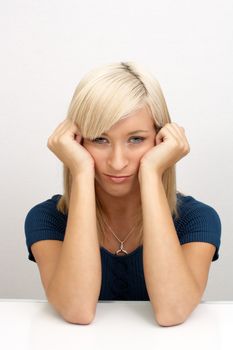 A studio close-up of a lovely young bored blonde.