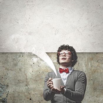 Young man with blank frames against a grey wall