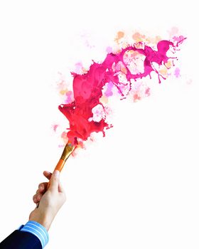 Close-up of human hand holding paint brush making colorful paint splashes