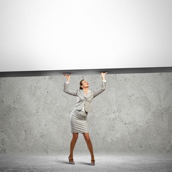 Businesswoman holding blank banner above head. Place for text