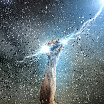 Close-up of human hand clenching lightning flash