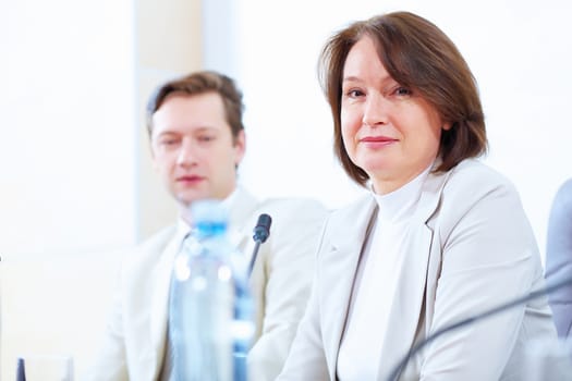 Image of two businesspeople sitting at table at conference