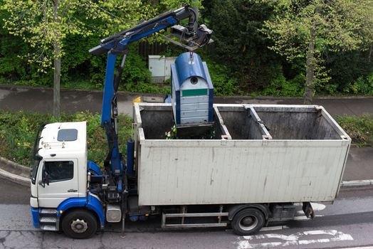 A truck is emptying recycling glass containers in Germany