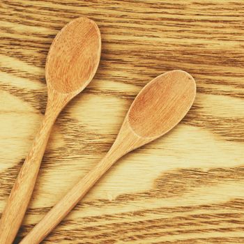 Two wooden spoons on table with retro filter effect